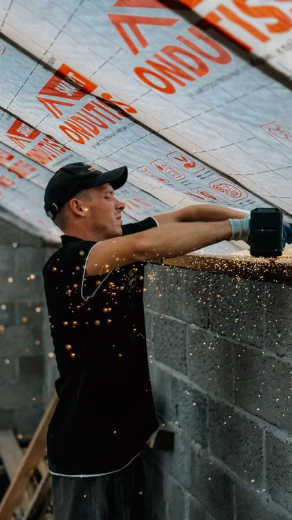 Tradesperson cutting masonry during a home construction project
